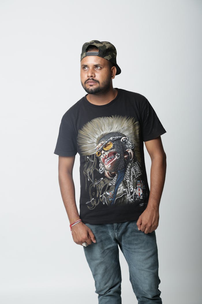 Bearded man in casual wear and cap posing in a studio.