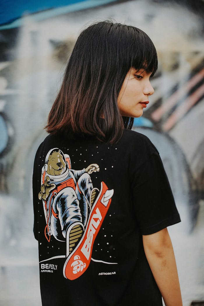 Asian woman with long hair modeling a graphic t-shirt in an urban setting